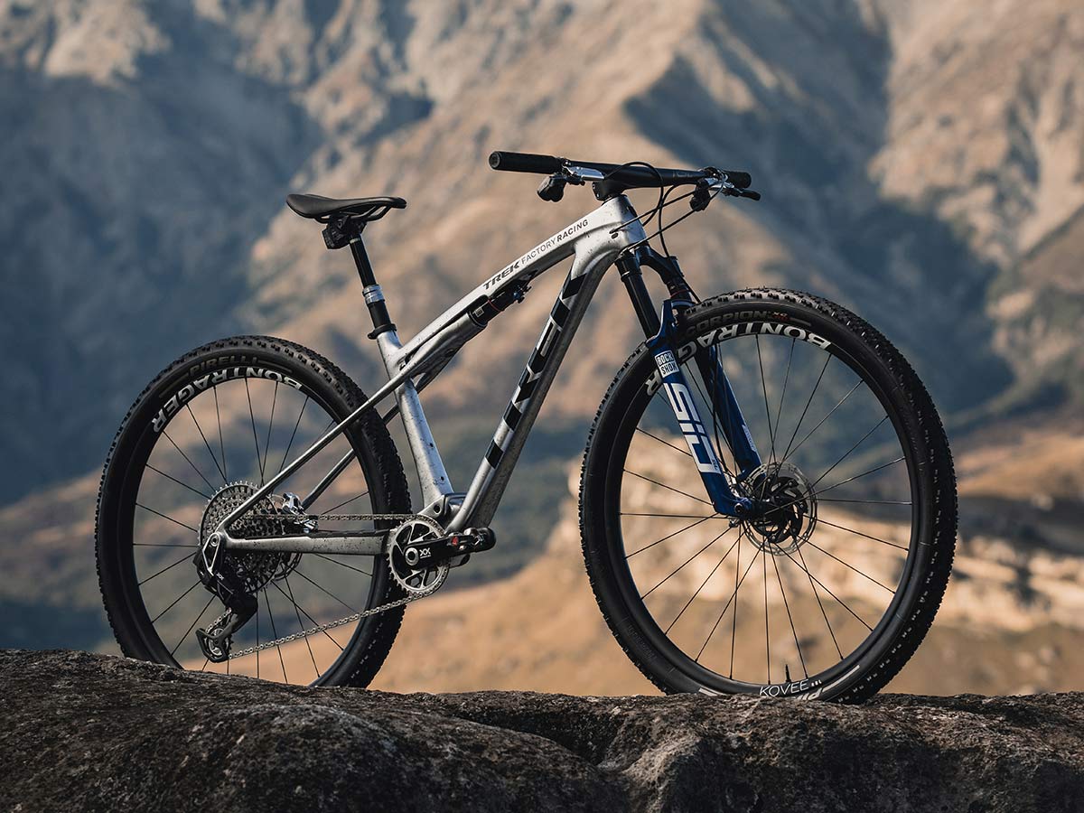 Supercaliber bike on a rocky mountain with more mountains in the background