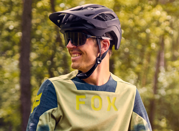 Smiling cyclist wearing helmet and sunglasses