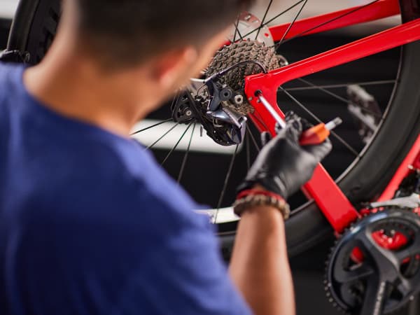 A red Trek Bicycle being tuned by a Trek Store employee in a blue shirt